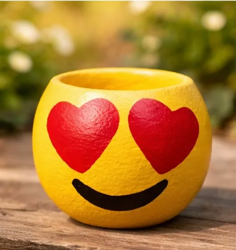Maceta de cemento con cara de emoji pintada a mano